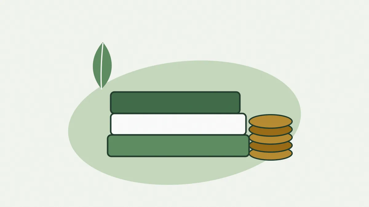 Une pile de trois livres colorés à côté de pièces de monnaie et d'une feuille